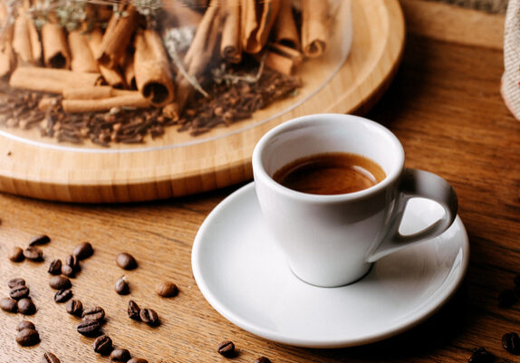front-view-coffee-along-with-cinnamon-coffee-seeds-around-brown-wooden-floor-1